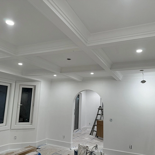 Professional interior painter repairing and sanding walls before painting in Amityville, NY.